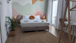 テルアビブにあるZuzu Studio apartmentsの壁に絵が飾られたベッドのある寝室