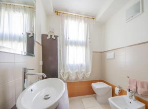 une salle de bain blanche avec un lavabo et des toilettes dans l'établissement Casa Ale e Ale Quartucciu sud Sardegna, à Quartucciu 14 autres photos