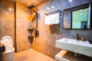 une salle de bain avec un lavabo, des toilettes et un miroir dans l'établissement The Paradise Apartment - 68 Luong Van Thang, Ninh Binh City, à Ninh Binh 143 autres photos