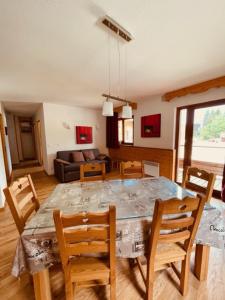 a dining room and living room with a table and chairs at Sunny Slopes Les Balcons de Recoin 6 pers in Chamrousse
