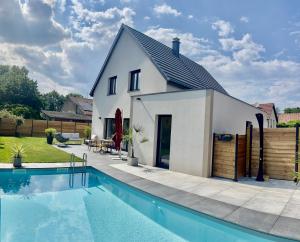 a house with a swimming pool in front of it at Gîtes du bel Alsace in Merxheim