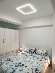 une chambre avec un lit avec un couvre-lit fleuri dans l'établissement Studio Tudor Eforie Nord, à Eforie Nord