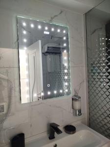 une salle de bain avec un miroir et un lavabo dans l'établissement Studio Tudor Eforie Nord, à Eforie Nord 36 autres photos