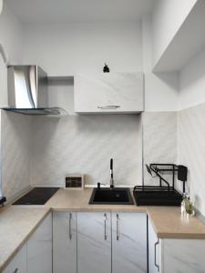 a kitchen with white cabinets and a sink at Studio Tudor Eforie Nord in Eforie Nord +36 photos