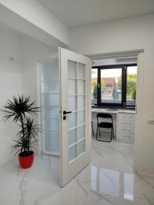 une porte ouverte dans une pièce blanche avec un bureau dans l'établissement Studio Tudor Eforie Nord, à Eforie Nord