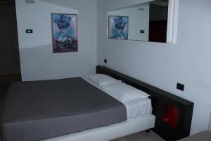 a small bedroom with a bed and a mirror at Blue Shades Hotel in Pisa