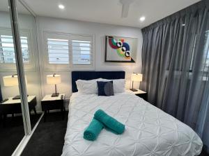 una camera da letto con un letto con due cuscini sopra di 2BR Apt Gungahlin Square Luxe Super Central Wifi Wine Secure Parking a Canberra