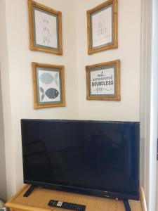 a computer monitor on a table with three pictures on the wall at Nisteri Seaside in Limenas