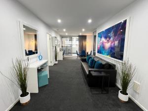 un ufficio con un divano e un grande dipinto sul muro di 2BR Apt Gungahlin Square Luxe Super Central Wifi Wine Secure Parking a Canberra