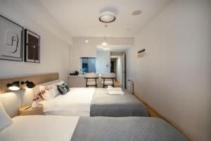 a bedroom with two beds and a kitchen at Tanimachi Namba East43 in Osaka