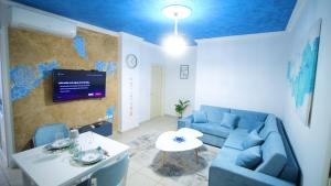 a living room with a blue couch and a table at Gjuhadol stay by Marina in Shkodër