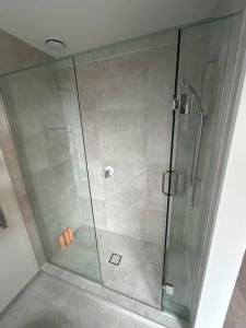 a shower with a glass door in a bathroom at Luxury 2 Bedroom Hideout Near CBD,Merivale Mall in Christchurch