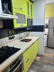 a kitchen with yellow cabinets and a sink at Piso de La Luna in Cazorla +15 photos