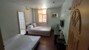 a small bedroom with a bed and a window at Ron Gong Hotel in Chiayi City