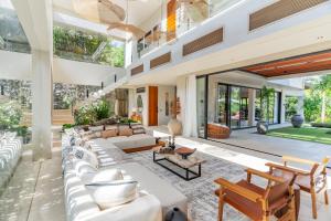 an open living room with couches and tables at Villa Morada Canggu by Nakula in Dalung