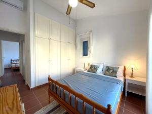 a bedroom with a bed with blue sheets and white cabinets at Mediterranean Cottage, Sea View, Great Location in Chlorakas