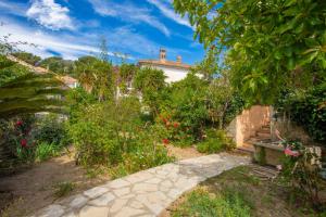 a walkway in a garden with flowers and plants at Appartement climatisé au Lavandou in Le Lavandou