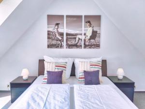 a bedroom with two beds and two pictures on the wall at Ferien im Fachwerkhaus mit Heimkino & Fitnessraum & Pools in Burgwedel