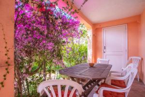 a table and chairs on a patio with purple flowers at Appartement climatisé au Lavandou in Le Lavandou +17 photos