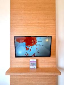 a flat screen tv sitting on top of a wooden wall at Swiss-Belinn Manyar in Surabaya