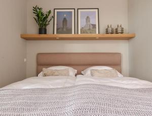 a bedroom with a white bed with two pillows at Nieuw-Brittenburg apartments I in Katwijk aan Zee