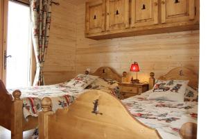 1 dormitorio con 2 camas en una cabaña de madera en Le Chalet d'Ulysse, en Arâches-la-Frasse