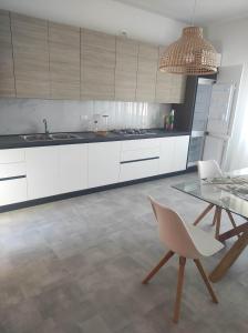 a kitchen with white cabinets and a glass table at B&B Esotica in San Giovanni Teatino