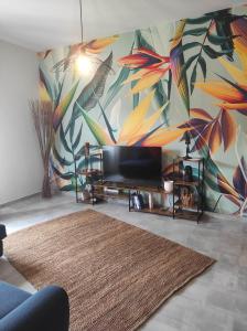 een woonkamer met een tv en een kleurrijke muurschildering bij B&B Esotica in San Giovanni Teatino