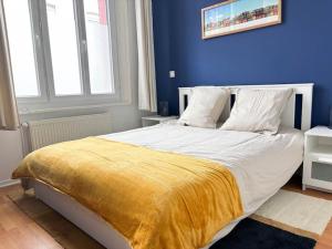 una camera da letto con un grande letto con una coperta gialla di Le Turenne à 400 m de la plage a Dunkerque