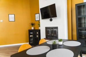 una sala da pranzo con un tavolo e una tv di Le Turenne à 400 m de la plage a Dunkerque