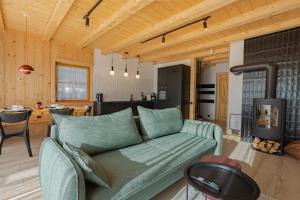 a living room with a couch and a kitchen at Osada Przystanek Czorsztyn in Czorsztyn