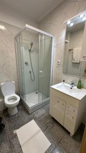 un bagno con doccia, WC e lavandino di Eral Apartment Mamaia a Mamaia