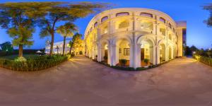a large white building with trees in front of it at The Grand Imperial - Heritage Hotel in Agra