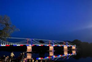 a bridge lit up at night with lights on it at Studio de standing en hypercentre proche Loire et parc in Châteauneuf-sur-Loire