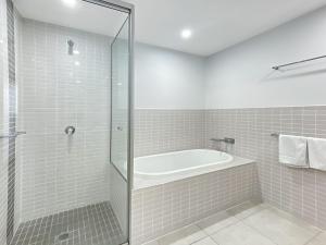 a white bathroom with a tub and a shower at Blue on Blue Apartment 1361 in Nelly Bay