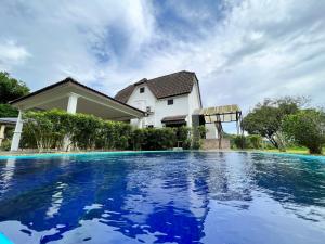 a house with a swimming pool in front of a house at Commons Pool Villa Lot 1021 - Fong Homestay in Kampong Alor Gajah