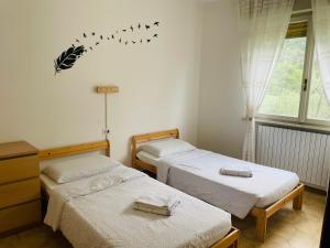 two beds in a room with birds on the wall at Casa Viktoria in Malcesine