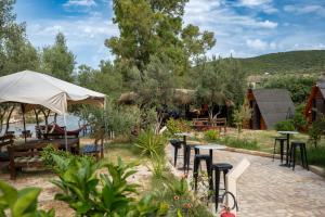 a group of tables and chairs in a garden at Garden Villa Lake Side & Glamping in Ksamil