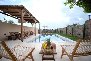 a patio with a pool and chairs and a table at stone villa marianna With private pool &guest studio in Moukhtároi