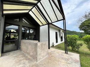 an external view of a house with a glass extension at Commons Pool Villa Lot 1021 - Fong Homestay in Kampong Alor Gajah