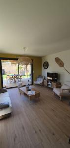 a large living room with couches and a table at Maison de plage Manoga in Saint-Germain-sur-Ay