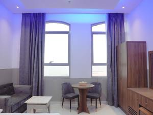 a living room with purple curtains and a table at Dream Point Hotel in Fujairah