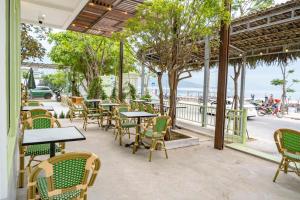 a patio with tables and chairs and the ocean at B&H Villa - Villa has swimming pool in Lang Co