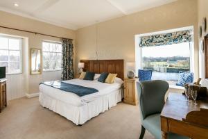 a bedroom with a bed and a desk and a window at Ednam House Hotel in Kelso