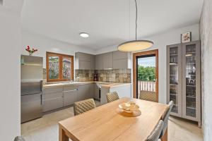 a kitchen with a wooden table and a dining room at Villa Ajlin with Private Pool in Sveti Lovreč Pazenatički
