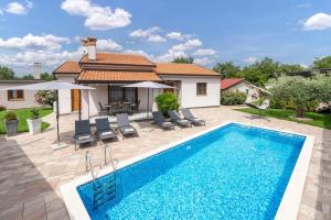 a villa with a swimming pool and a house at Villa Ajlin with Private Pool in Sveti Lovreč Pazenatički