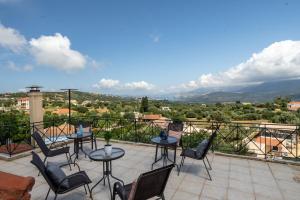 a patio with chairs and tables on a balcony at Eraora Lofts & Apartments Kefalonia in Lakithra