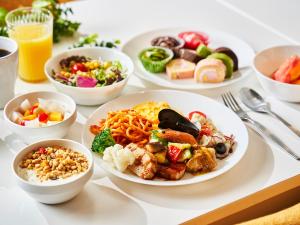 a table with plates of food and bowls of food at Kobe Sannomiya Union Hotel in Kobe
