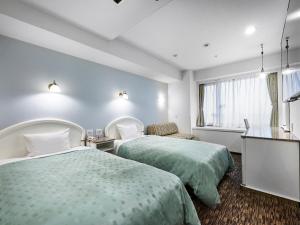 una camera d'albergo con due letti e una finestra di Kobe Sannomiya Union Hotel a Kobe