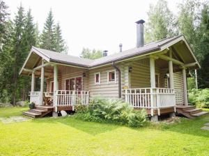 Cette petite maison en bois dispose d'une terrasse couverte. dans l'établissement Välituvan lomamökit, à Punkaharju